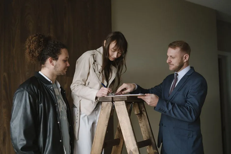 Deux personnes relisant un compromis de vente sur une table, stylo et dossiers, ambiance bureau.