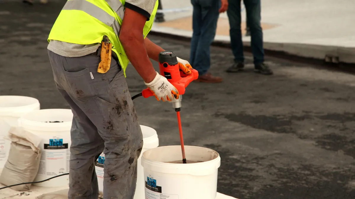 Préparation de béton dans une brouette avec ciment, sable et gravier sur un chantier