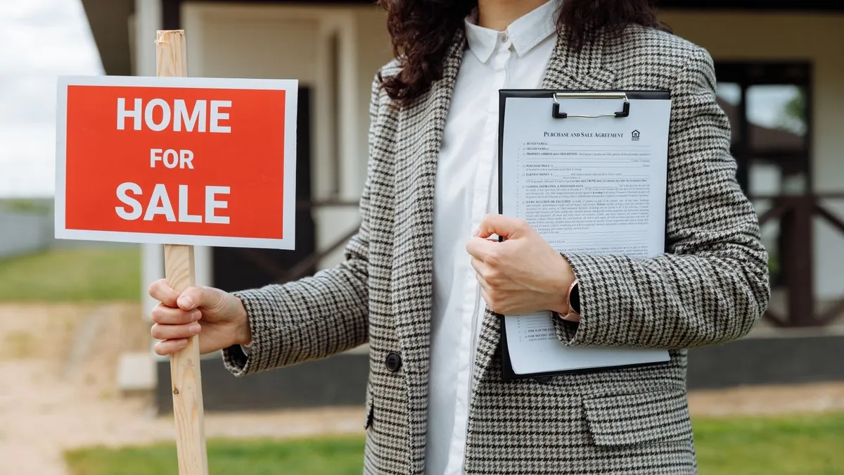 Portail métallique rouillé devant une maison, volets tachés à rénover avant mise en vente