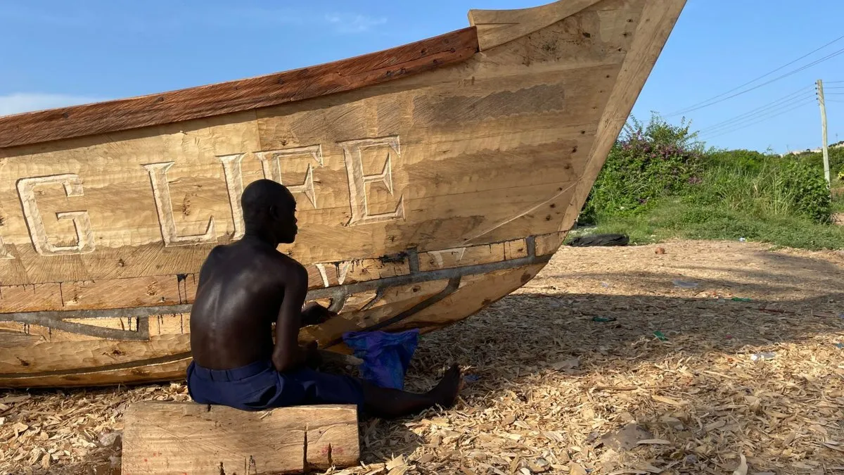 Ber en bois sous un bateau calé dans un jardin, avant la vente de la maison