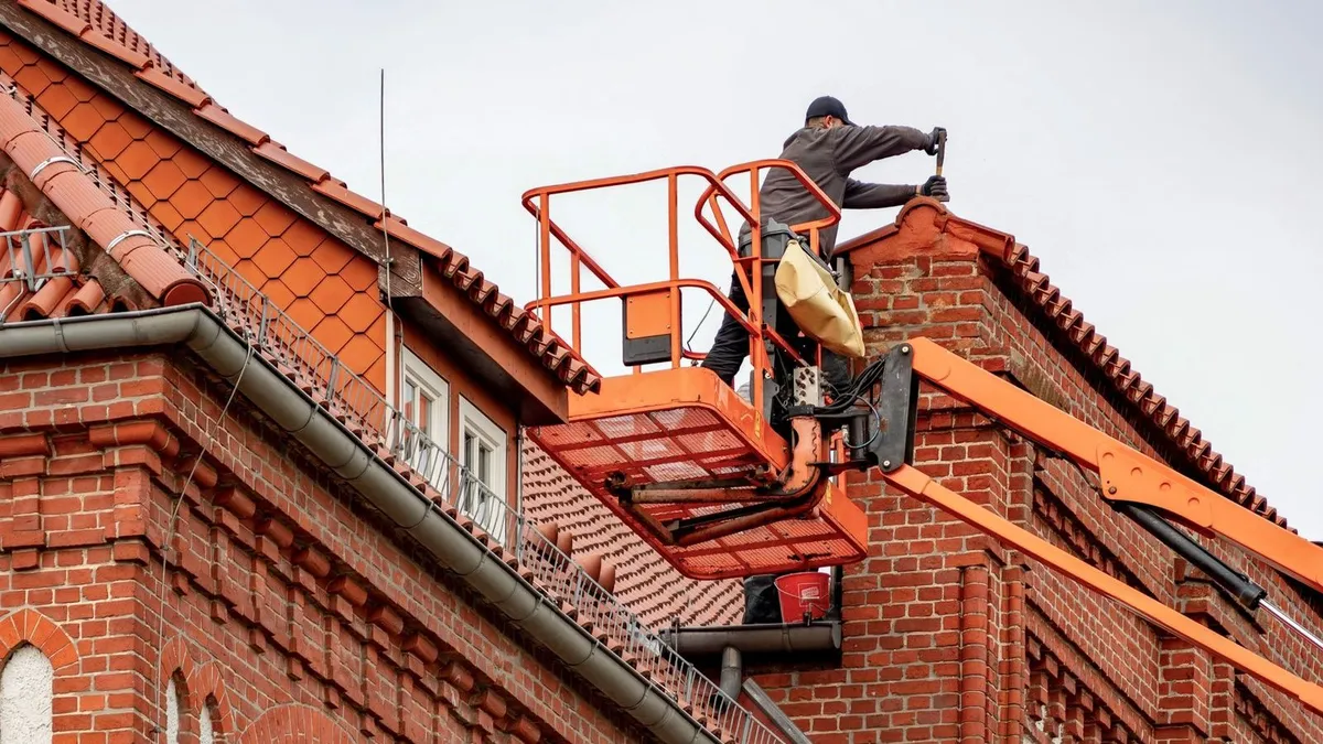 Toiture en tuiles rouges encrassées vue de près avec mousse verte et traces noires avant nettoyage