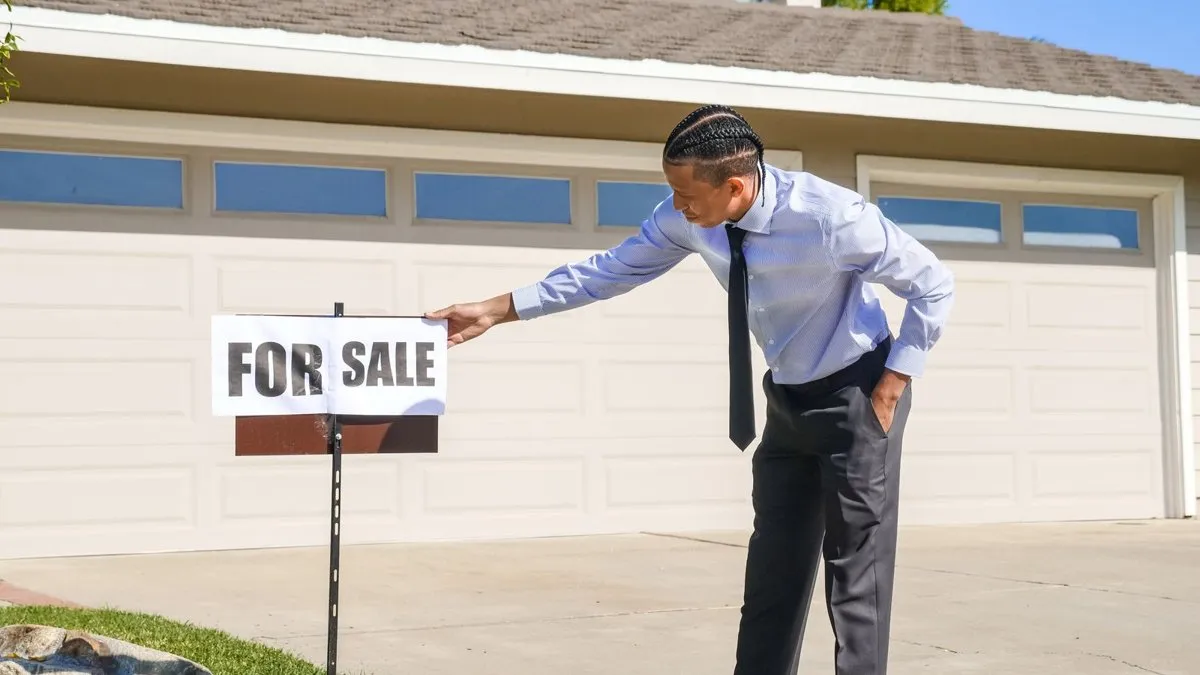 Garage rangé avec établi net, outils triés et cartons empilés avant une vente immobilière