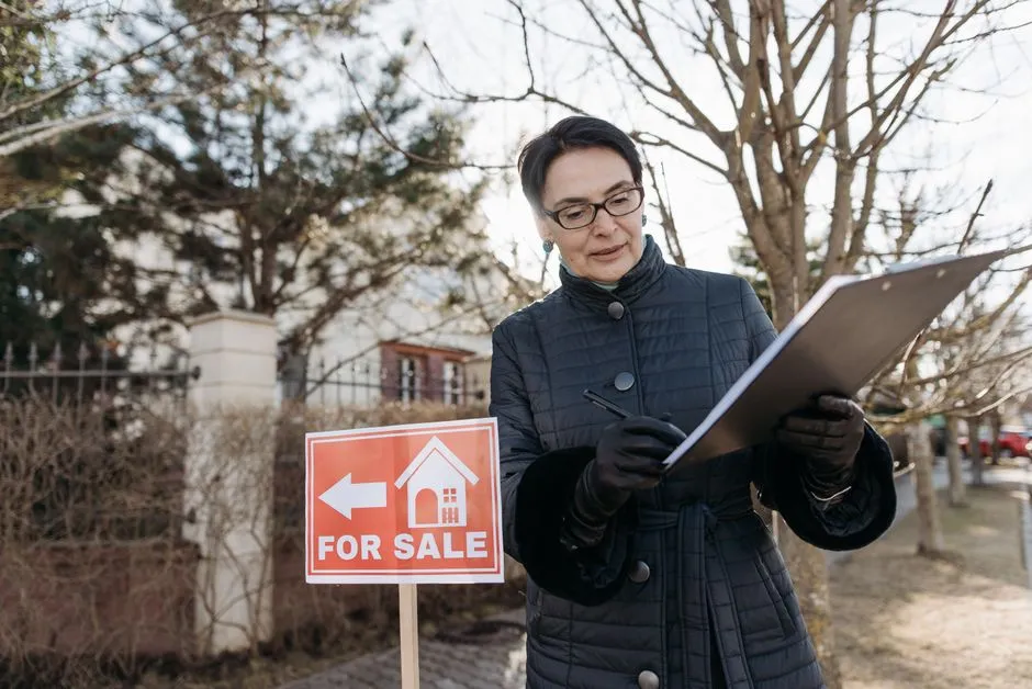 Bureau avec ordinateur portable affichant une annonce immobilière rédigée, plan du logement à côté