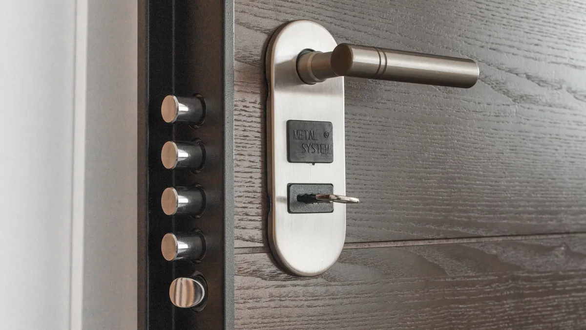 Gros plan sur une serrure de porte d'entrée en laiton et sa clé, poignée chromée